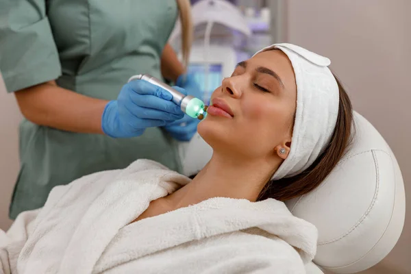 Young woman getting aesthetic skin treatment in beauty spa salon — Fotografia de Stock
