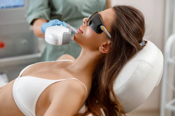 Genç bir kadın güzellik salonunda estetik yaptırıyor.