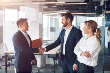 Takımımıza hoş geldiniz, modern modern modern erkekler modern ofiste el sıkışıyorlar.