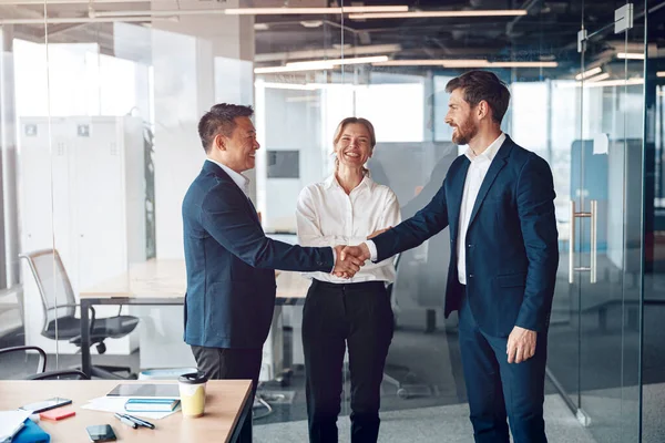 Genç mutlu lider, yeni projeyi kutlamak için iş adamıyla tokalaşıyor.