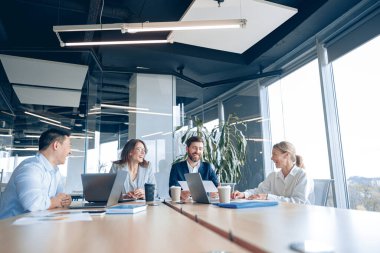 Modern ofiste panoramik görünümlü yaratıcı iş adamları proje üzerinde çalışıyor