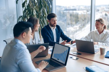 Creative business team working on project in modern office with panoramic view