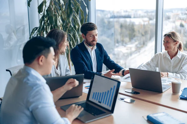 Modern ofiste panoramik görünümlü bir proje üzerinde çalışan yaratıcı iş ekibi