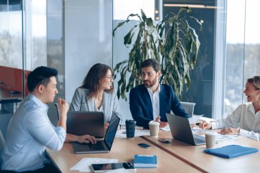 Modern ofiste panoramik görünümlü bir proje üzerinde çalışan yaratıcı iş ekibi
