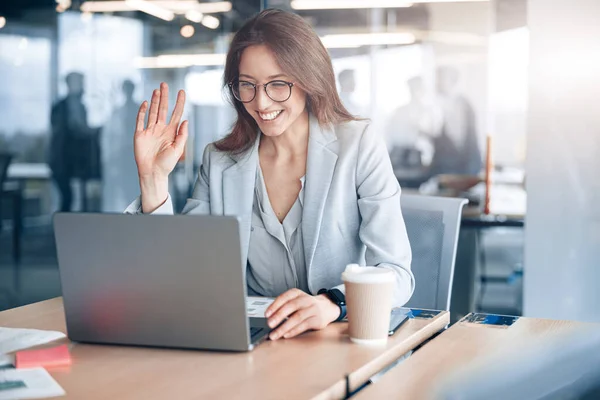 Confident businesswoman communicating in video call with client at her workplace at modern office — 스톡 사진