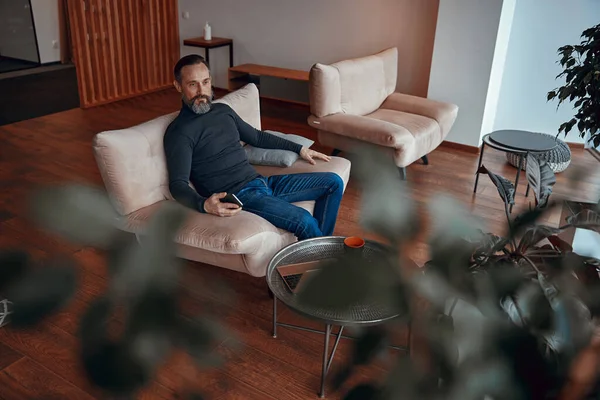 Kafkasyalı adam rahat lobide dinleniyor.