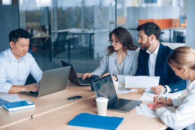 Creative business people working on project in modern office with panoramic view