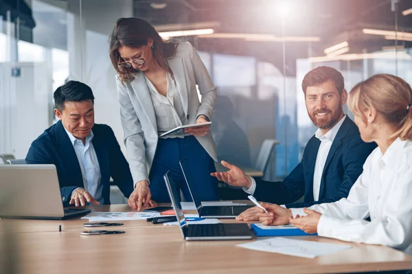 Um grupo de parceiros de negócios durante uma reunião de equipe definida no escritório moderno — Fotografia de Stock