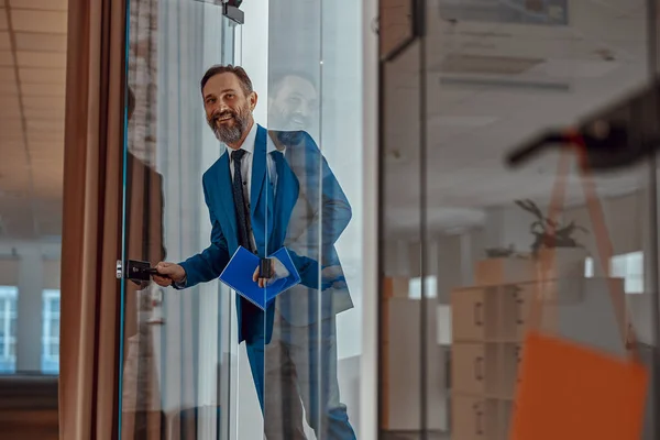 Happy businessman opening the office door and looking inside — ストック写真