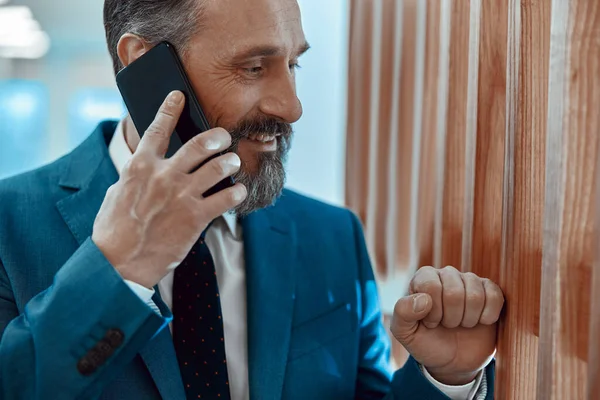 Happy businessman having an important conversation on mobile phone — ストック写真