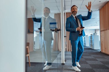 Şık takım elbiseli gülümseyen işadamı meslektaşını selamlıyor.