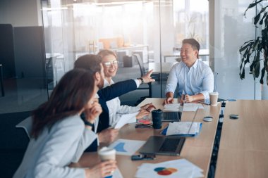 Modern bir ofiste birlikte çalışan Asyalı genç işadamlarının olumlu çalışmaları.. 