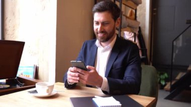 Cep telefonunda sohbet eden ve mesaj atan mutlu genç bir adam. Neşeli iş adamı.