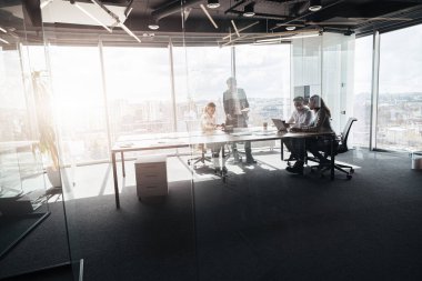 Modern ofiste panoramik görünümlü yaratıcı iş adamları proje üzerinde çalışıyor