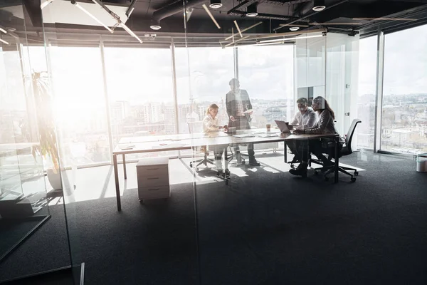 Modern ofiste panoramik görünümlü yaratıcı iş adamları proje üzerinde çalışıyor