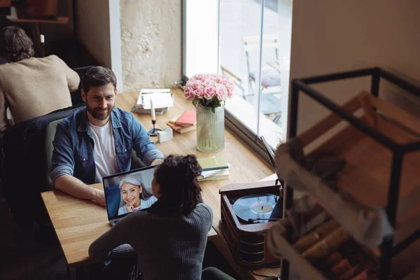 Kafeteryadaki neşeli kadın ve erkek sohbetleri. Dizüstü bilgisayardaki yaşlı kadın. Toplantı.