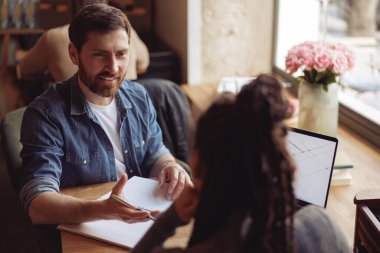 Beyaz tenli yakışıklı adam kadın ortağa iş teklifini açıklıyor. Ortaklık kavramı.