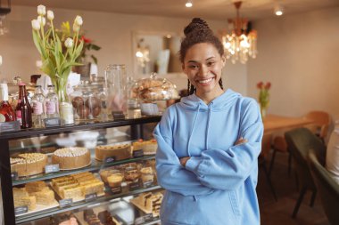 Kahve ve pastanenin genç ve güzel bayan müşterisi kameraya gülümsüyor..