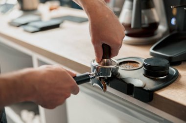 Espresso yapmak için kahveleri dolduran baristaya yaklaş.