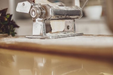 Mutfak tahtasının üzerinde duran hamurlu erişte keskisi.