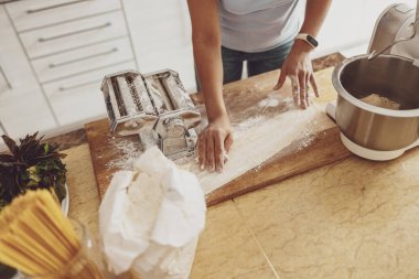 Bir kadın erişte dilimleyicisine para göndermek için tahtanın üzerine yuvarlanır.