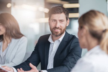 Kendine güvenen ve başarılı bir takım. Bir grup modern insan ofiste birlikte çalışıyor.