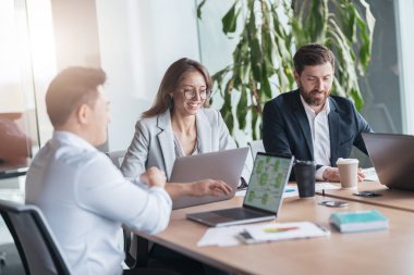 Şirket işletme ekibi ve yönetici, modern ofiste panoramik pencereli bir toplantı odasında.