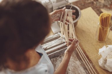 Evde bir kadının yaptığı erişte pişirme işlemi.