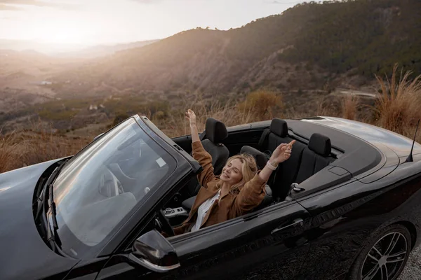 Caucasian beautiful happy relaxed woman in cabriolet traveling alone feeling free. Journey concept
