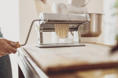 Bir kadının eli, içine hamur sıkıştırılmış bir makarna bıçağının sapını büker.