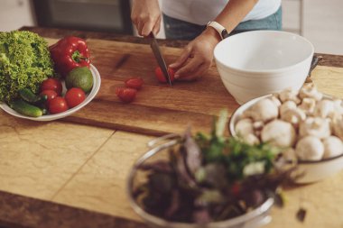 Mutfakta domates, salatalık, mantar ve fesleğen kullanarak salata hazırlıyorum.
