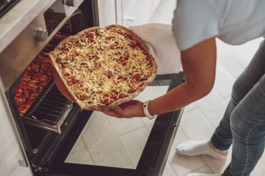Genç bir kadın fırına ev yapımı pizza yolluyor.