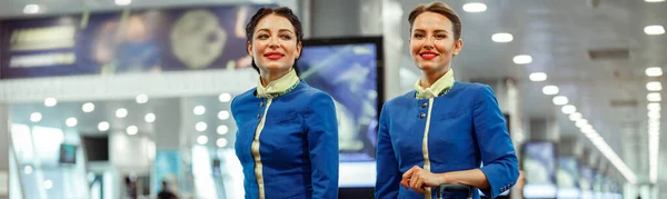 Asistentes Vuelo Sonrientes Uniforme Azafata Aviación Llevando Bolsas Viaje Aeropuerto —  Fotos de Stock