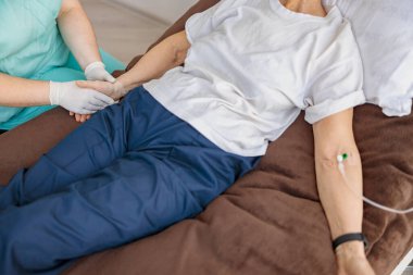 Profesyonel hemşire, modern tıp kliniğindeki hastasının serumunu kontrol ediyor. Yüksek kalite fotoğraf