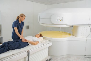 Radyoloji uzmanı MRI ya da CT taramasını hasta işlemleri ile kontrol ediyor. Yüksek Teknoloji Tıbbi Ekipmanı