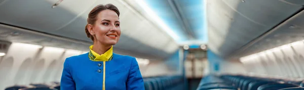 Wesoła Stewardessa Mundurze Stewardessy Lotniczej Stojącej Alejce Salonu Pasażerskiego Samolotu — Zdjęcie stockowe