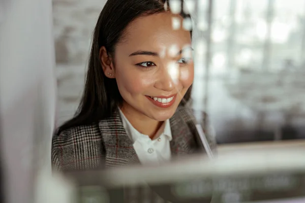 Portrait of smiling asian business woman standing behind glass in office. Close up