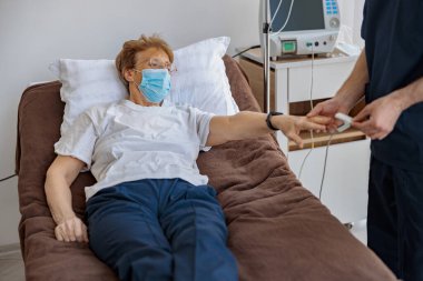 Hemşire parmak ucuyla nabız oksimetreli oksijen doygunluğunu kontrol ediyor. Yüksek kalite fotoğraf