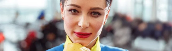 Close up of woman stewardess or flight attendant looking at camera and resting chin on hand in glove
