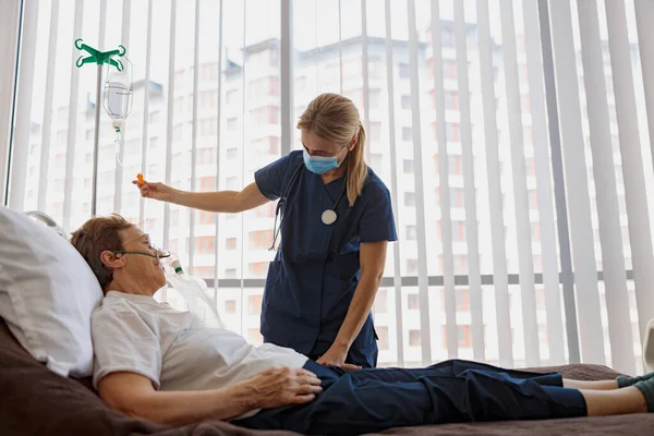 Doctor supporting a sick patient before medical procedures in a hospital room. High quality photo