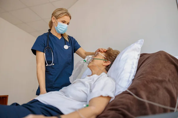 医者はCovid 19の女性患者の呼吸マスクをつける 高品質の写真 — ストック写真