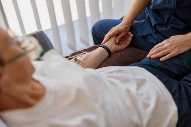 Doktor hasta bir kıdemli hastayı hastane odasında tutarak onu destekliyor.