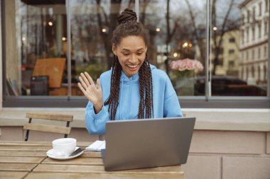 Neşeli, şık, genç bir bayan kameraya el sallıyor ve görüntülü konuşuyor. Görüntülü arama. Video Hattı.