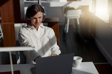 Attractive european business woman working laptop while sitting in cozy cafe. Blurred background
