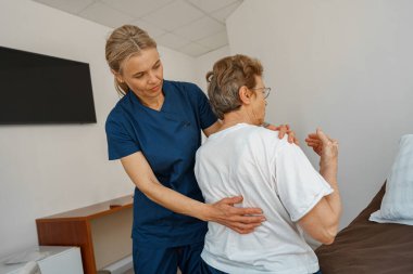 Professional doctor in uniform examines the patient during a visit to hospital ward in clinic