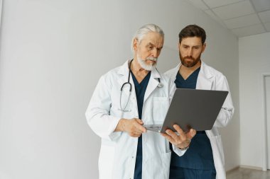 Two doctor colleagues discussing patient diagnosis stand in medicine clinic hall. High quality photo