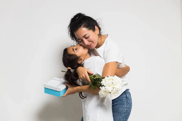 Cute baby girl gratulując kochającej mamy, dając bukiet białych kwiatów, pudełko z prezentami. Dzień Kobiet lub Matki — Zdjęcie stockowe