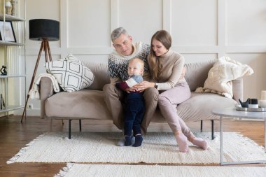 Evinin arka planında, fotokopi odası olan küçük oğlu olan mutlu genç bir aile. Kiralama, taşınma, ipotek konsepti