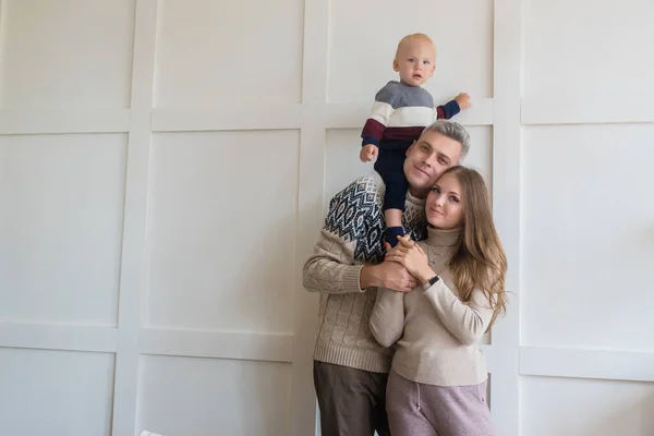 Feliz família jovem com filho criança no fundo da parede do apartamento cinza com espaço de cópia. Aluguer, movimentação, conceito de hipoteca — Fotografia de Stock