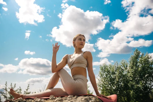 Genç bayan dışarıda koştuktan sonra esniyor ve dinleniyor. Yoga savaşçısı pozunu düşünüyor..